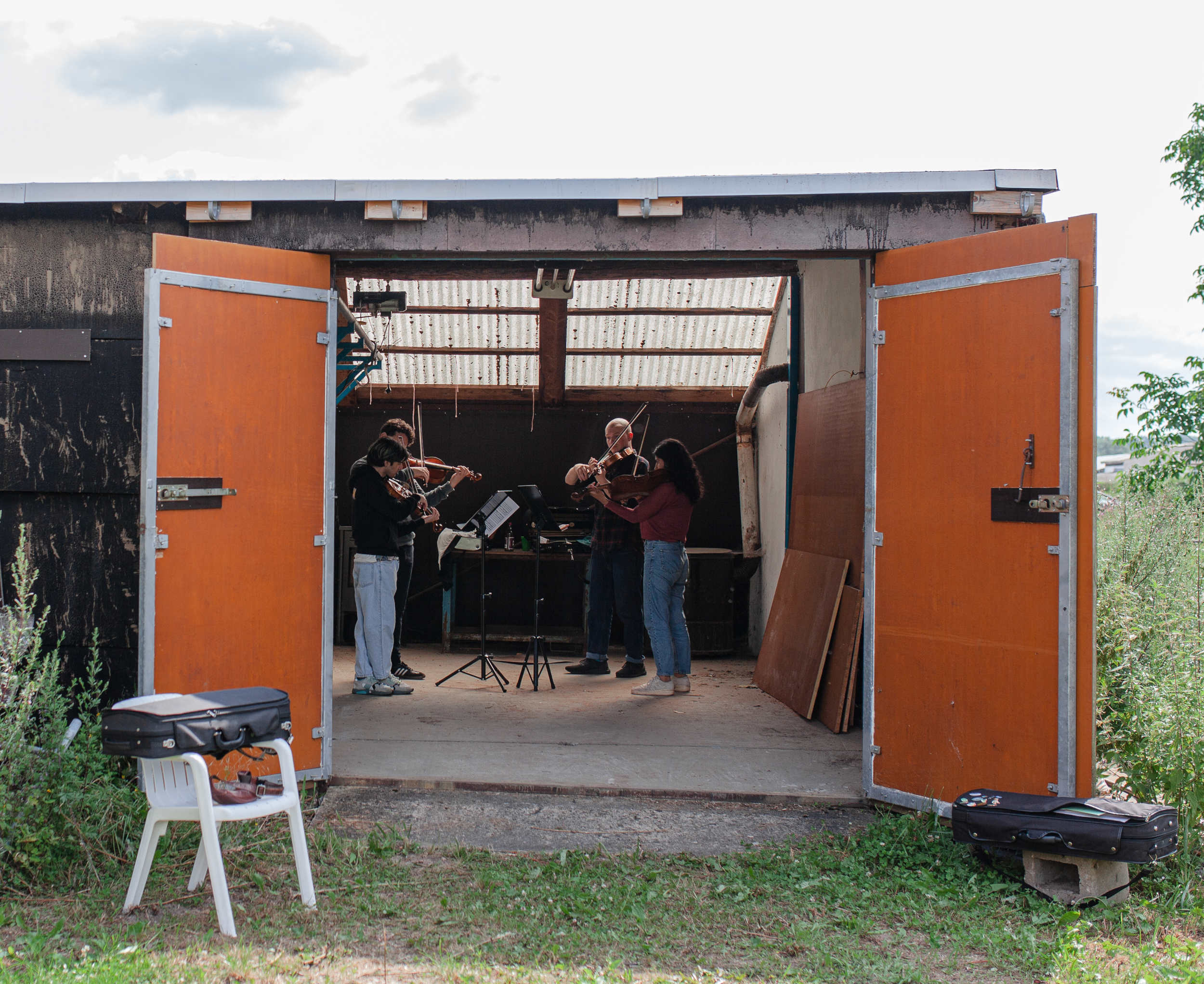 Musikerinnen und Musiker sichtbar von hinten aus dem Orchester heraus fotographiert, im Hintergrund ist ein Mond projeziert